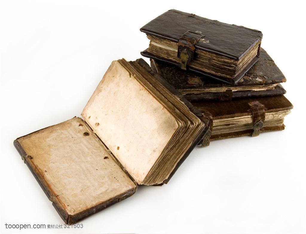 古老书籍-一本展开的书和三本堆放在一起的书摆放在一起