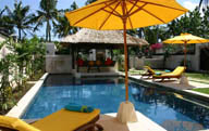 酒店游泳池旁太阳伞下的躺椅