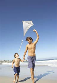 在海边手拉手的父子两放风筝